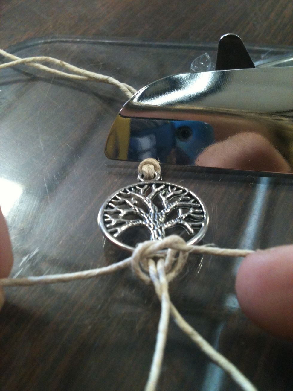 Take your really long string and tie a simple knot around the string attached to the pendant. (as shown)