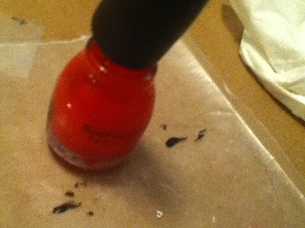 Take your red polish and put it either on the top of your nail or right above your cuticle.