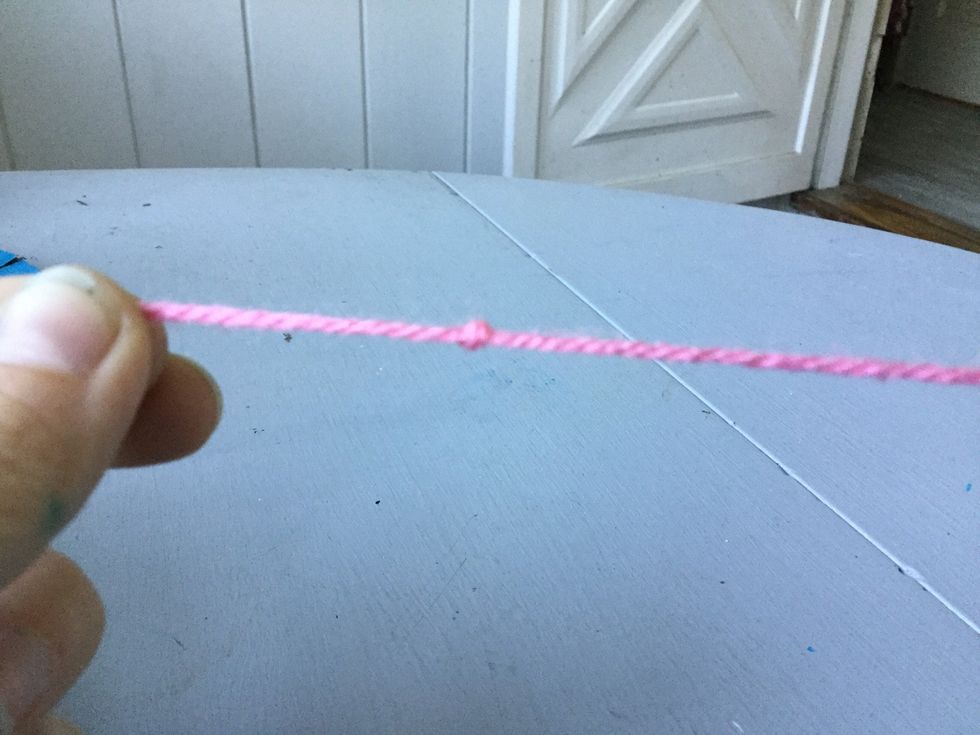 Take your second ball of yarn and tie a knot on one end