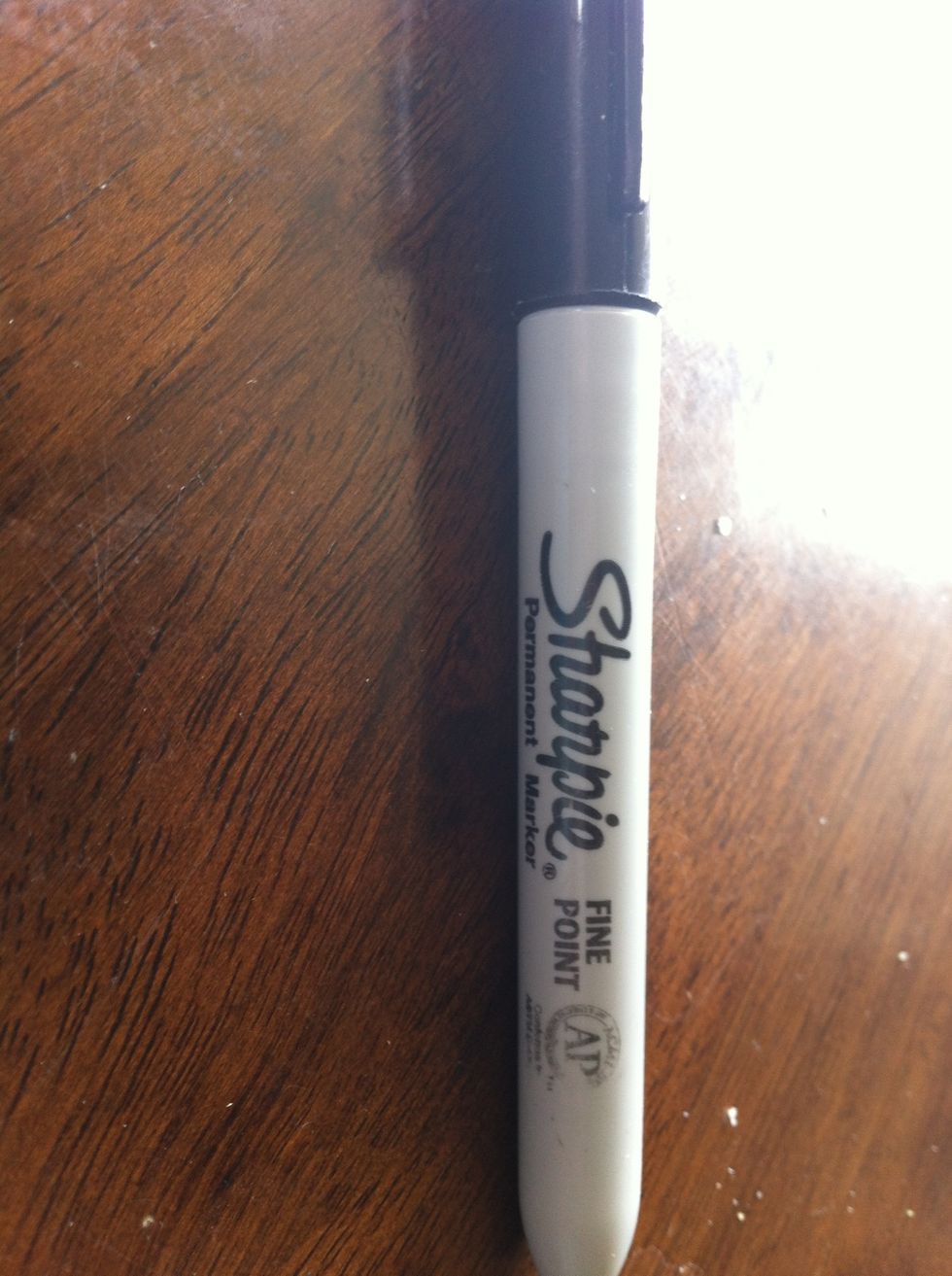 Take your sharpie and color over as much as you can until you cant see it any more