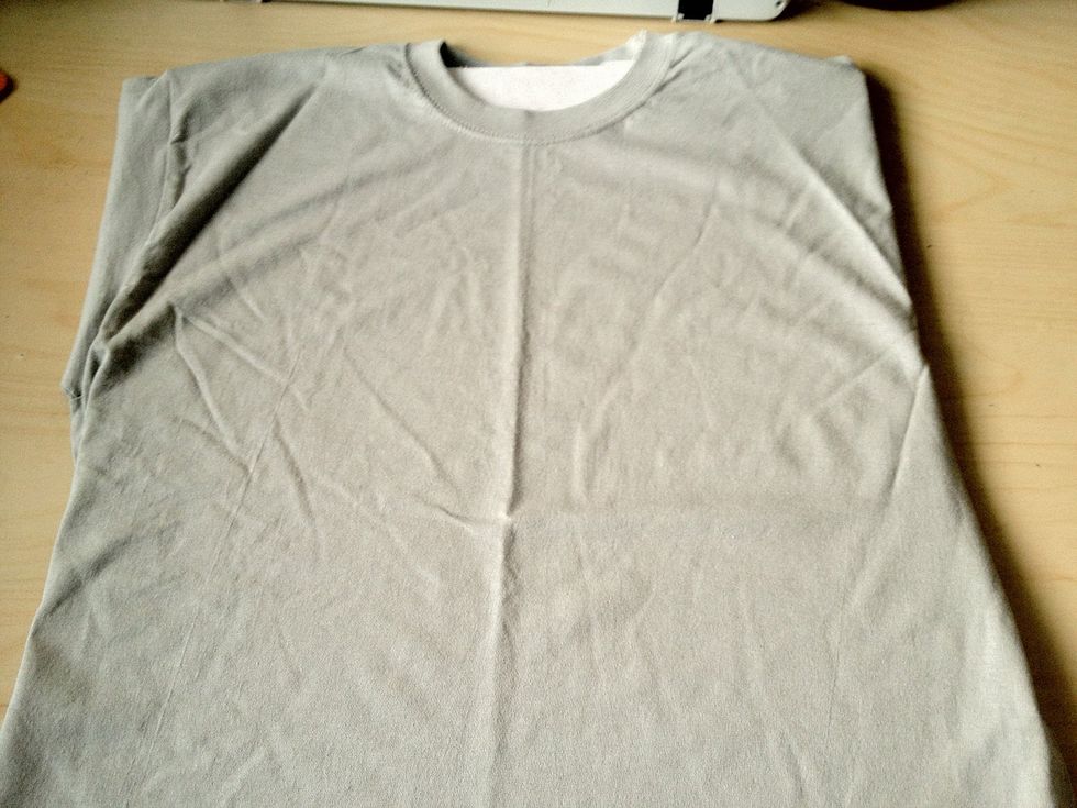 Take your shirt and put some old cardboard inside. This will stop the paint soaking through to the other side. I just used a piece I cut from an old box. Tuck any excess fabric underneath.