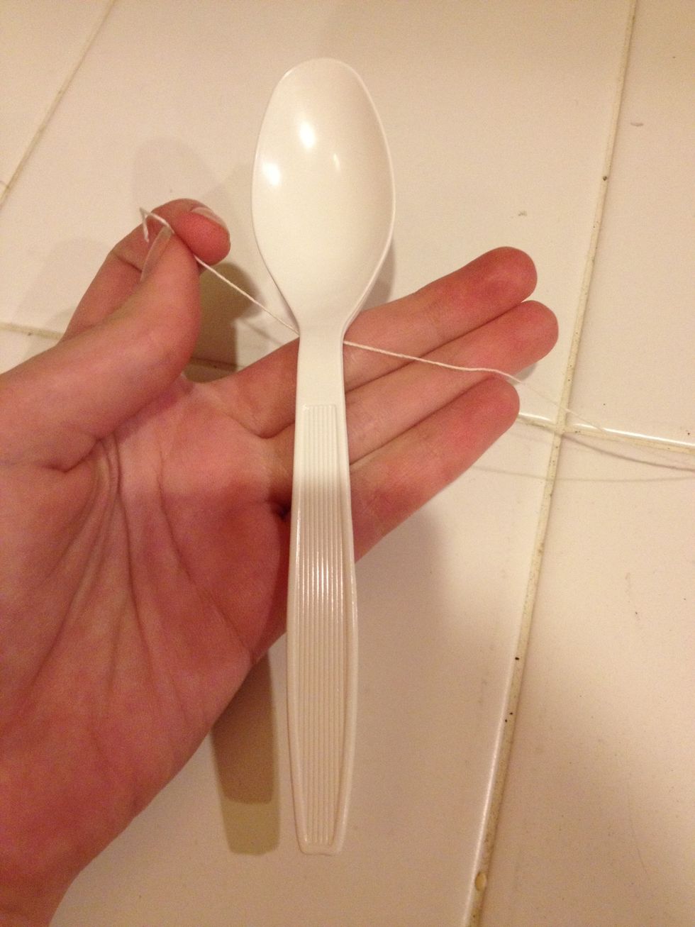 Take your spoon (any type) and tie the string in a knot under the handle but before the cup itself.