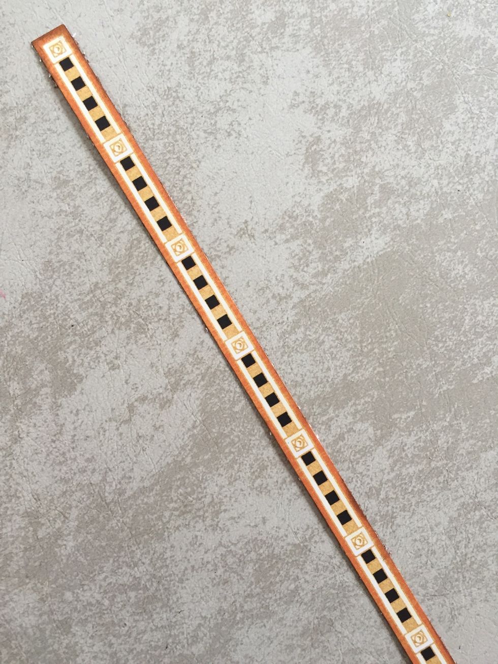 Take your Wicked Whimsey paper and use a paper trimmer to cut off this strip.