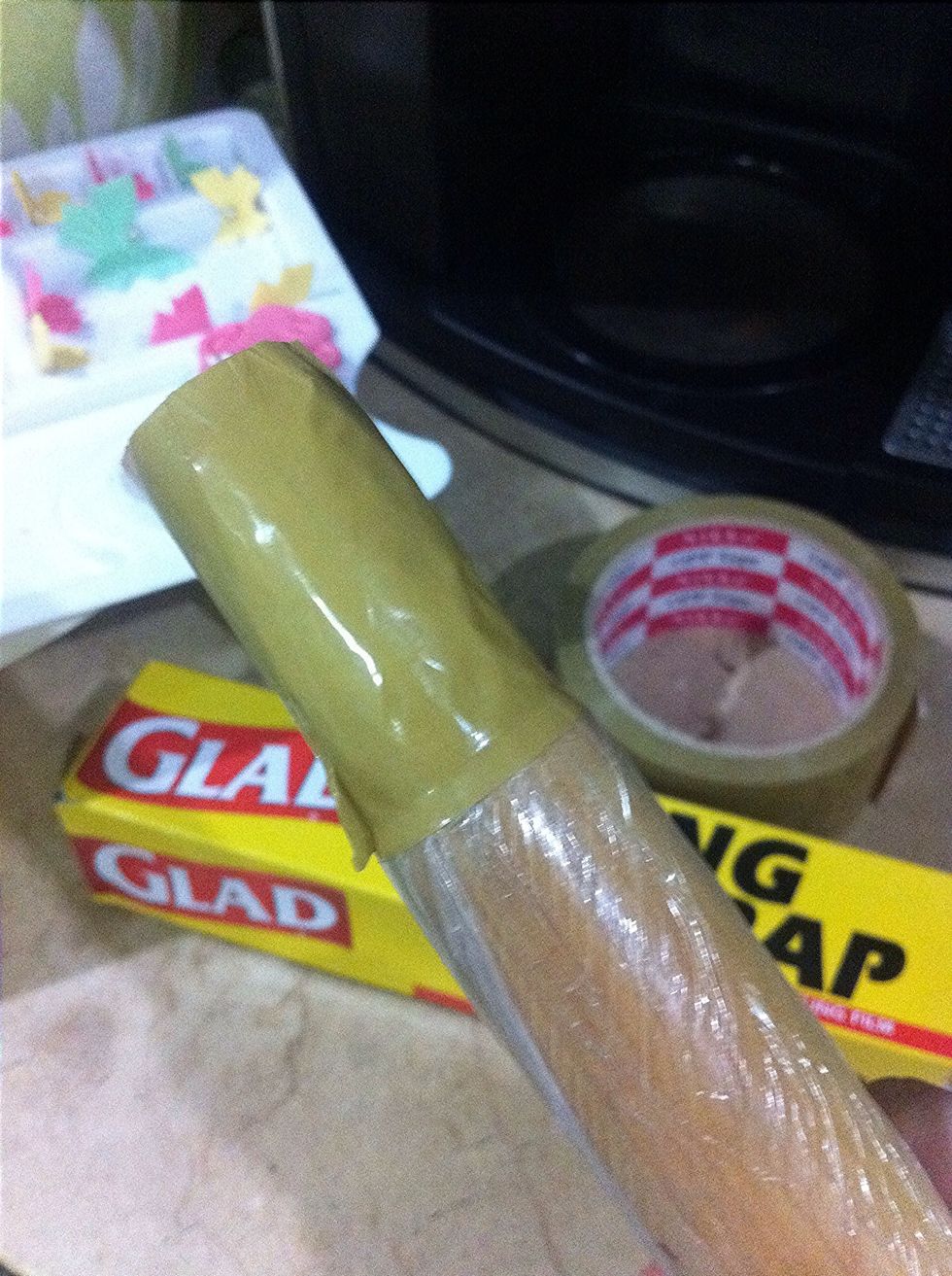 Take your wooden rolling pin and wrap it nicely with glad wrap. Cut masking tape and tape both sides of the rolling pin.