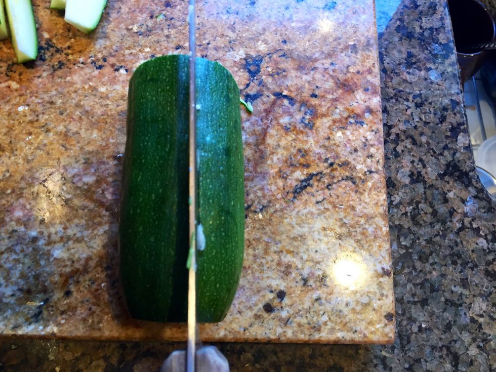 Take zucchini half, spin it "up and down" and cut in half again.