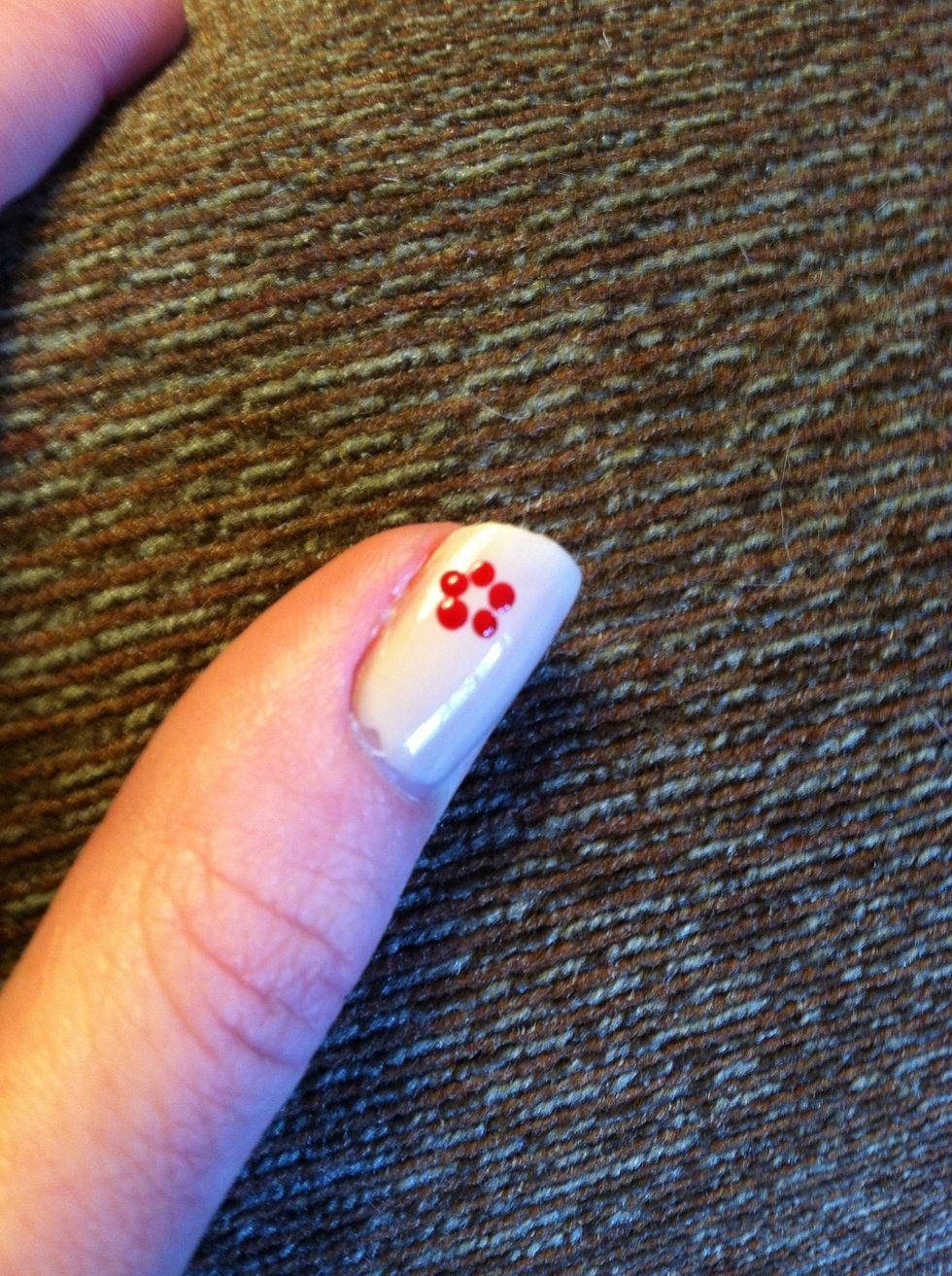 Taking a doting tool, place 5 dots in a small circle.