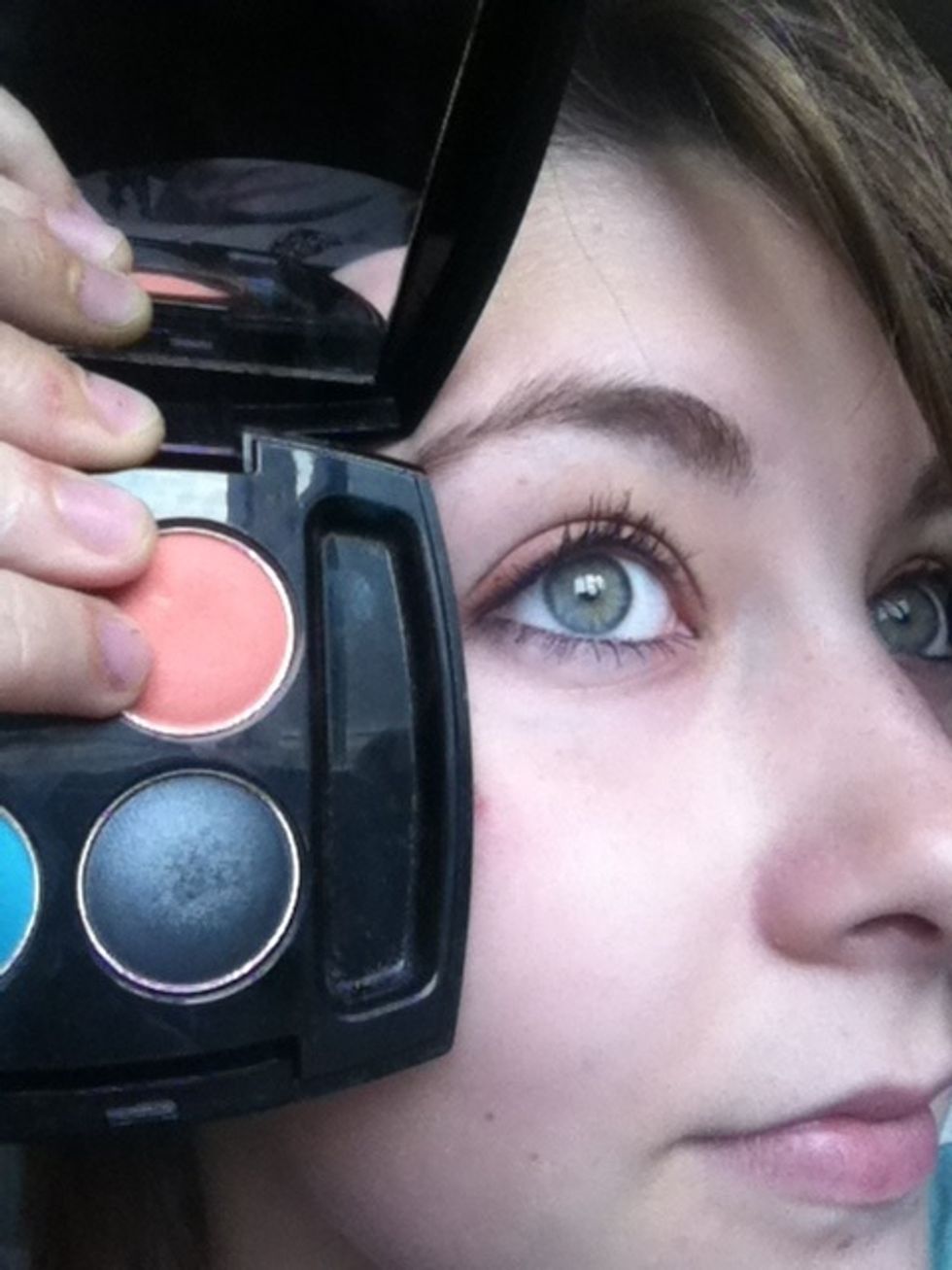 Taking a flat eyeshadow brush, sweep the coral eyeshadow across your lid.