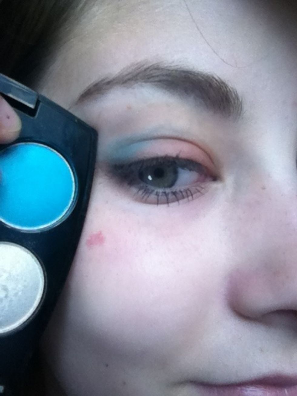 Taking a rounded blending brush, apply the bright blue to the outer corner of your lid and blend inwards.