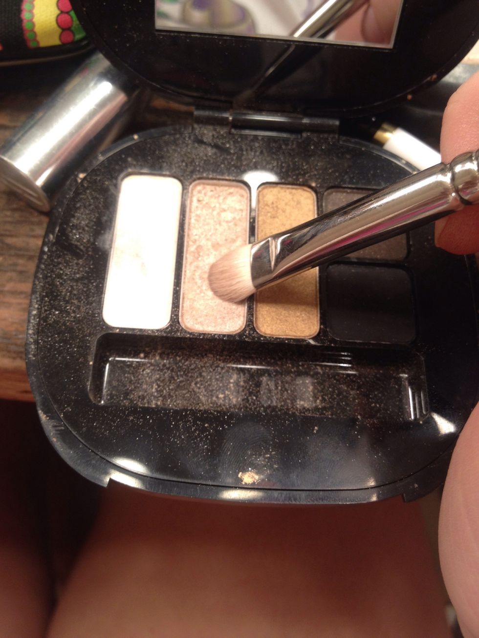 Taking my first brush used and dip it into a nude shimmery color.