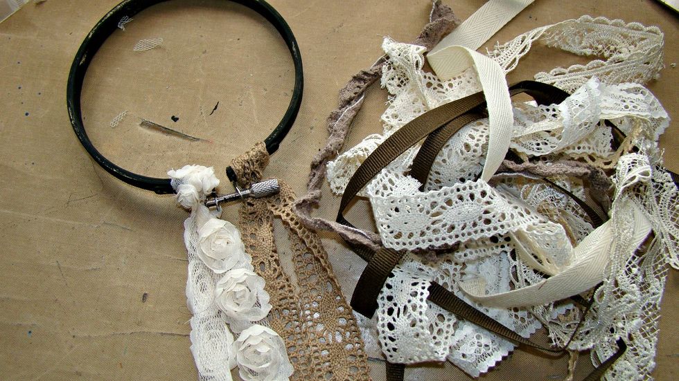 Taking random pieces of laces and trims and cut different lengths including strings of pearls and tide them to the smalles hoop This will be the backdrop for my clock face.