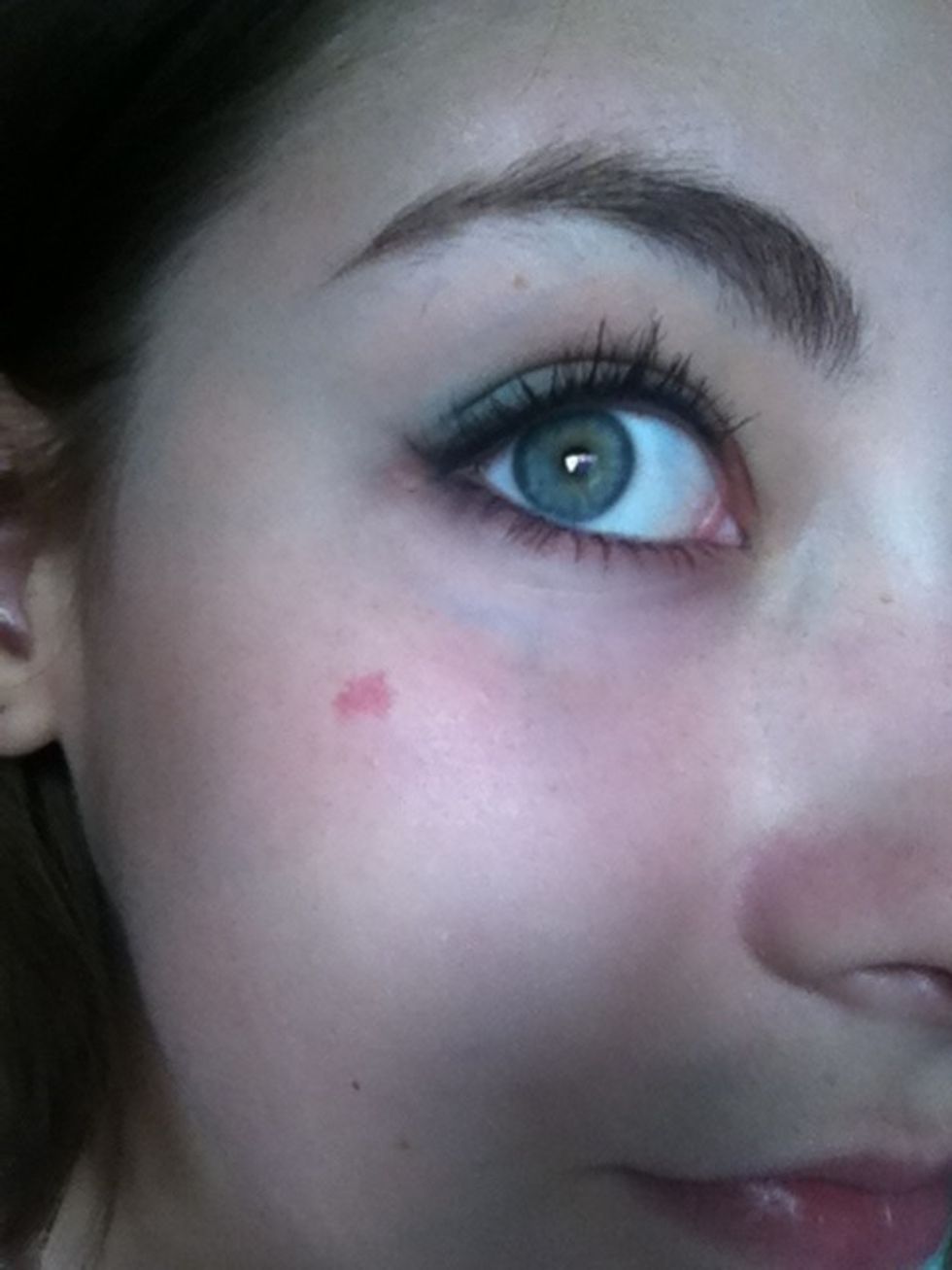 Taking the same small angled brush, line your lower lid with the coral eyeshadow.