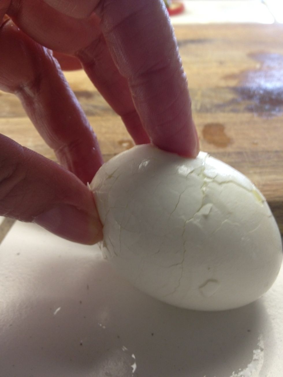 Tap on counter and roll with the palm of your hand to loosen the shell