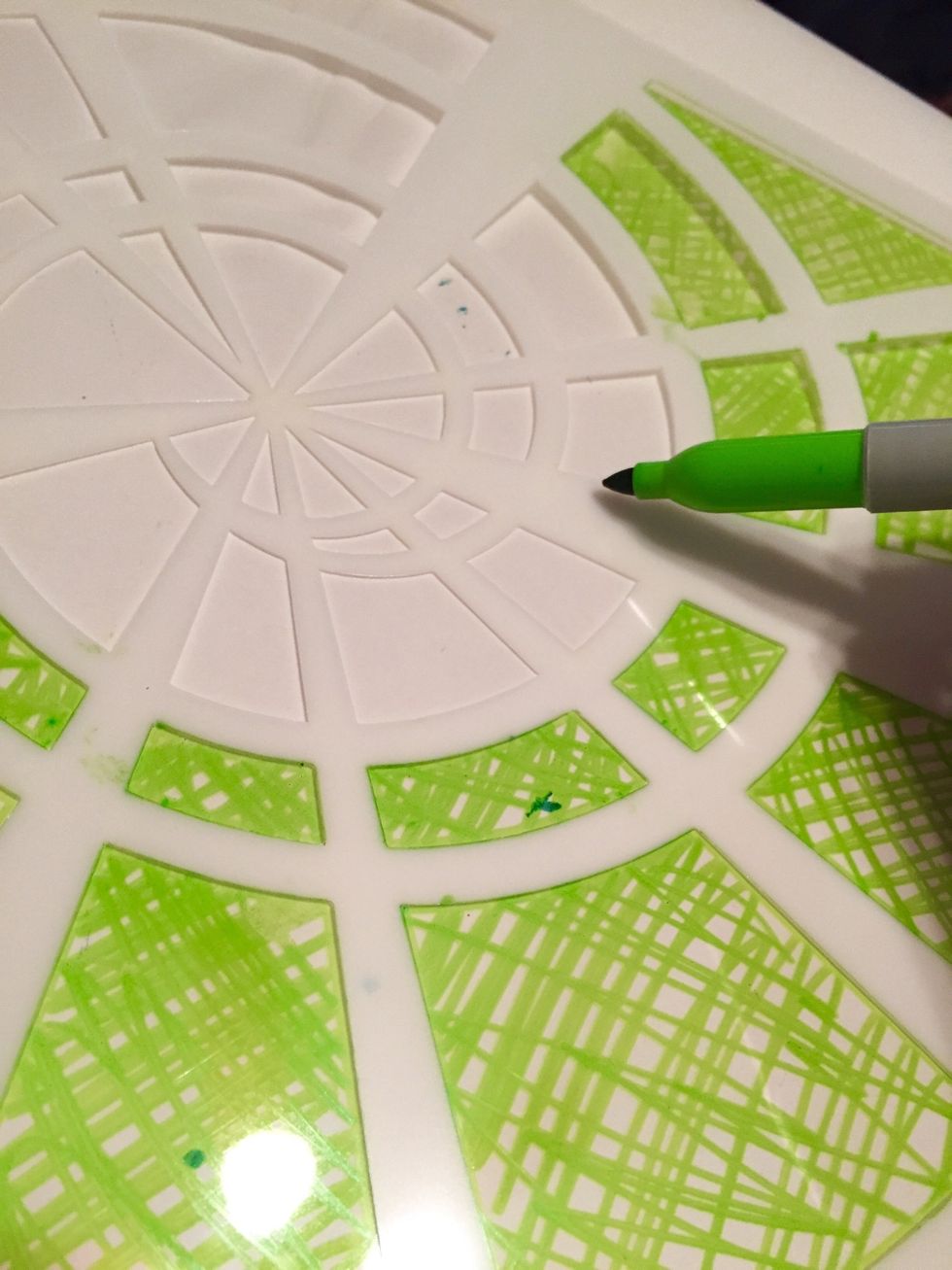 tape another sheet of Shrink Film down to work surface. begin to fill in design with a cross-hatch pattern using Lime Sharpie. reposition stencil and retape as needed to add designs to whole sheet.