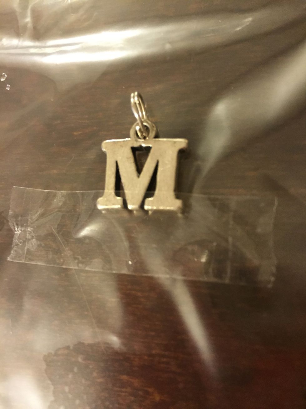 Tape it onto the bottom of your charm.