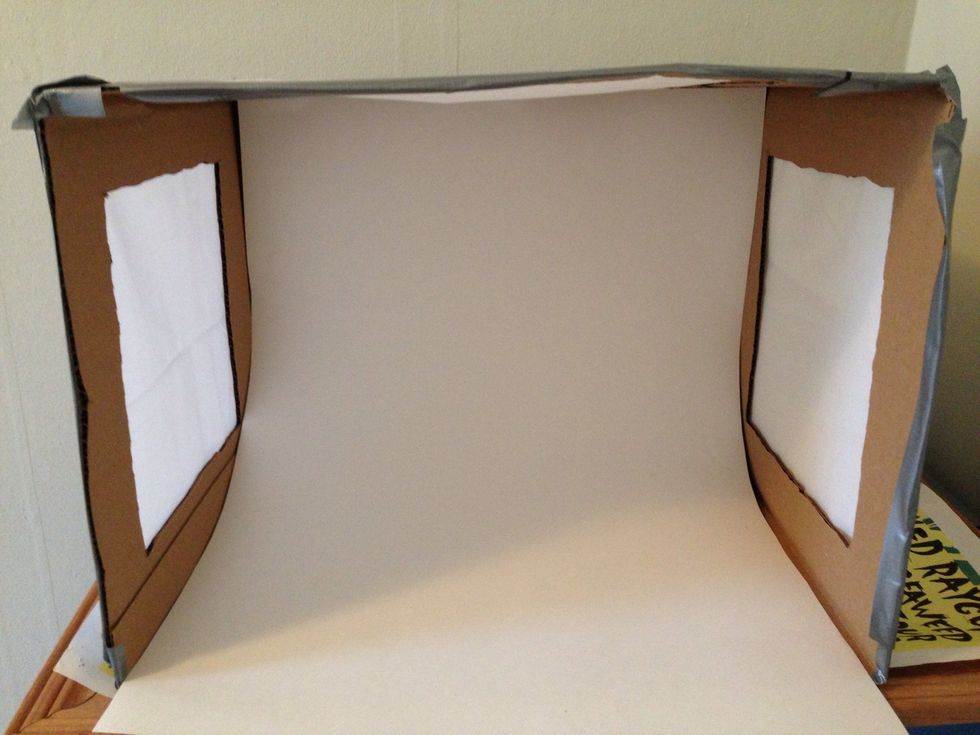 Tape or glue your poster board to the inside of the light box and allow it to bend out.