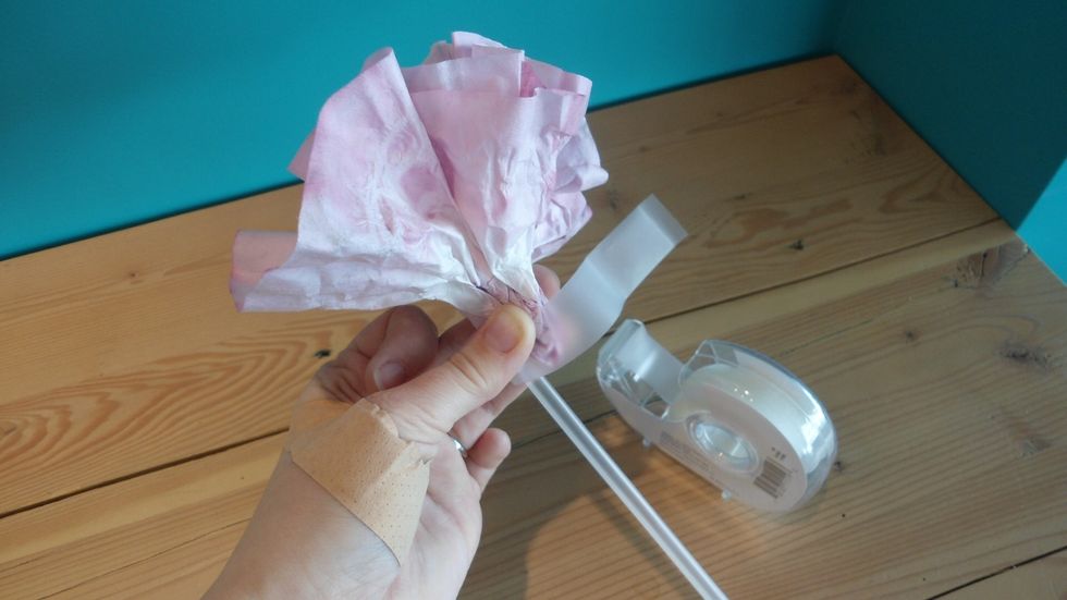 Tape the flower to the straw.