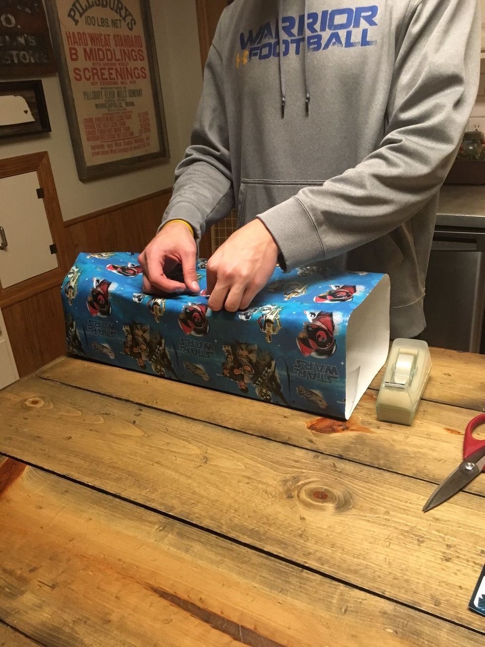 Tape the other end of the wrapping paper down.