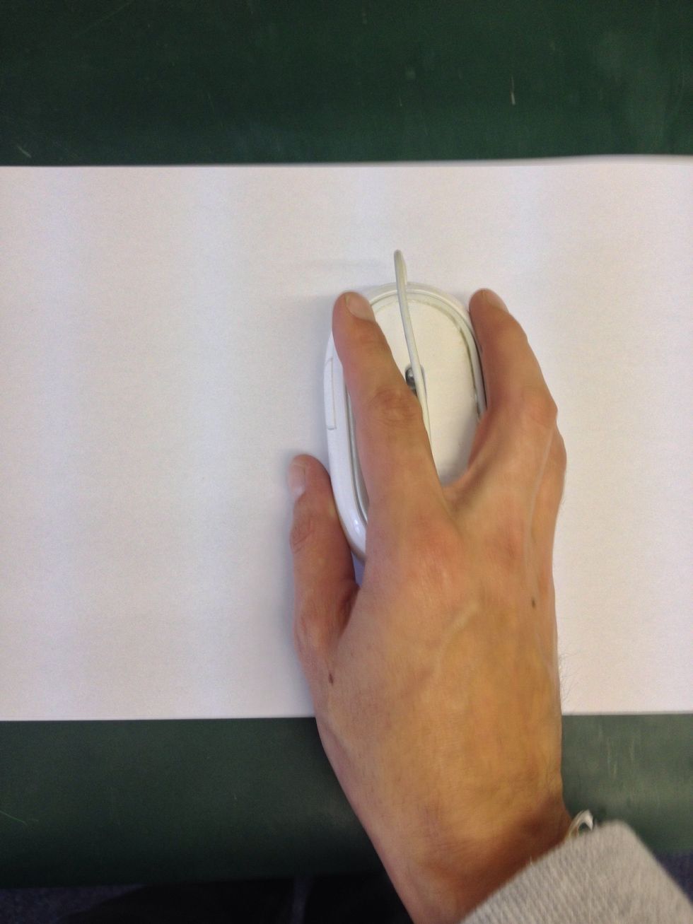 Tape the paper to a hard surface at two opposite corners. Grip the Mighty Mouse upside down with the scroll ball touching the paper.