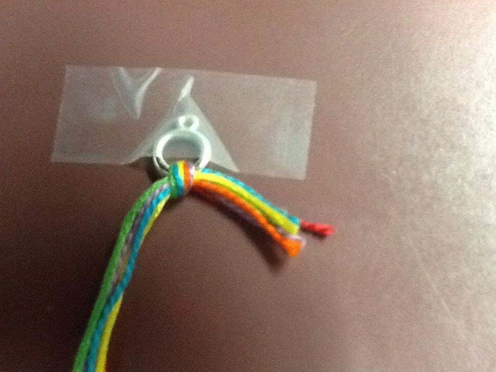 Tape the ring down to a flat surface, such as a table.