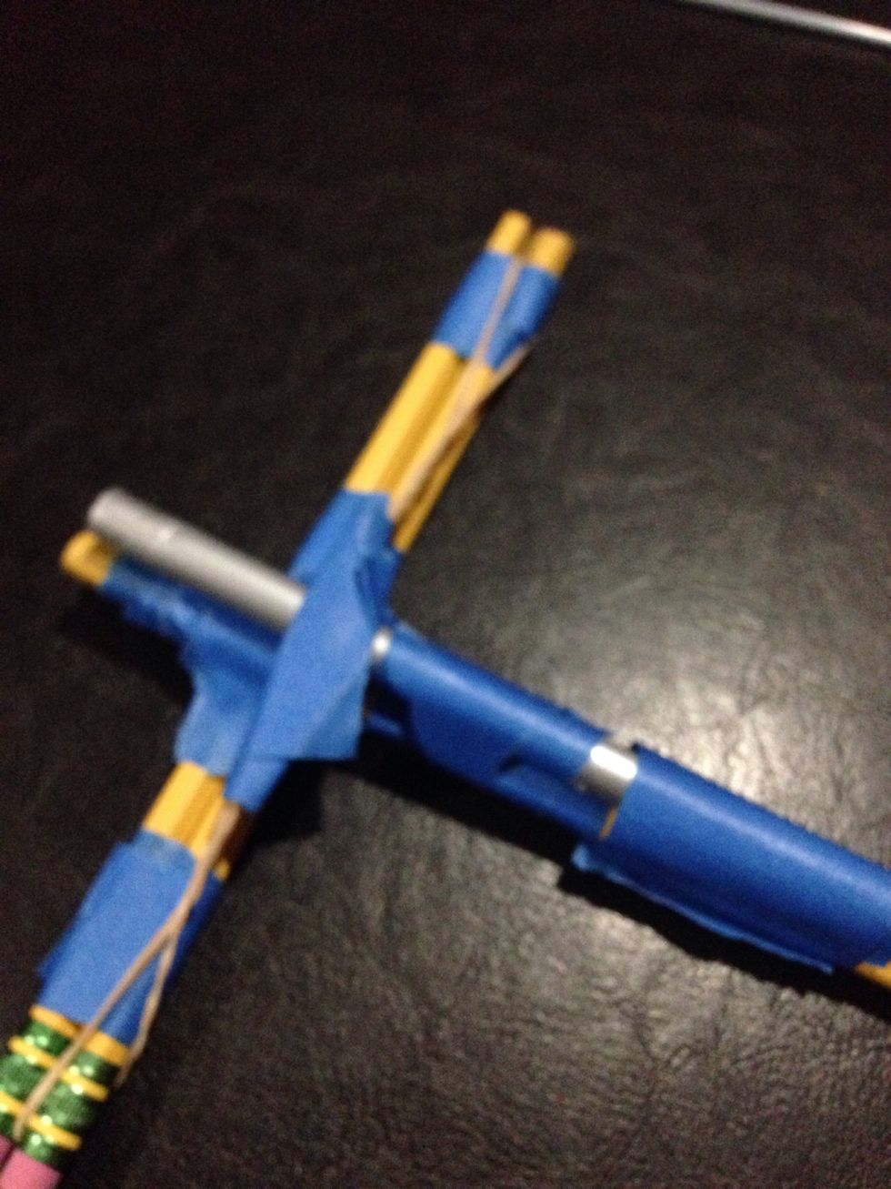 Tape the tube of your pen and add tape it to the body of the crossbow, have the drawstring rest on top.