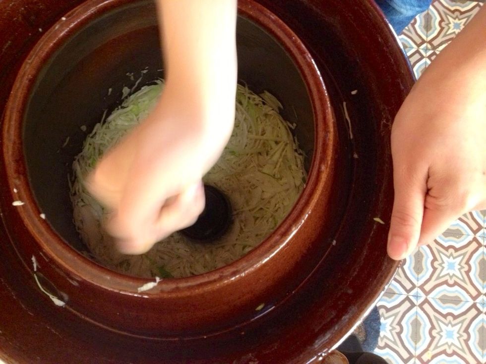 Tasser le choux vigoureusement (\u00e0 l'aide d'un pilon) au fur et \u00e0 mesure dans le r\u00e9cipient et en intercalant r\u00e9guli\u00e8rement du cumin et des baies de geni\u00e8vre.