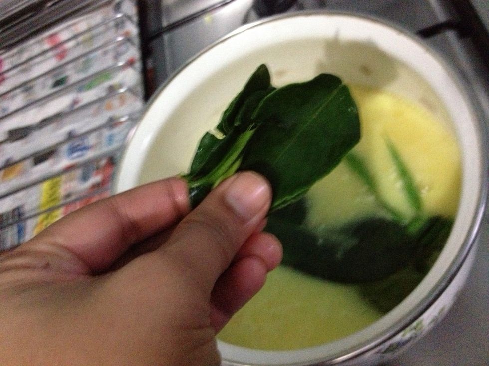 Tear 5 kaffir lime leaves and add them into the pot