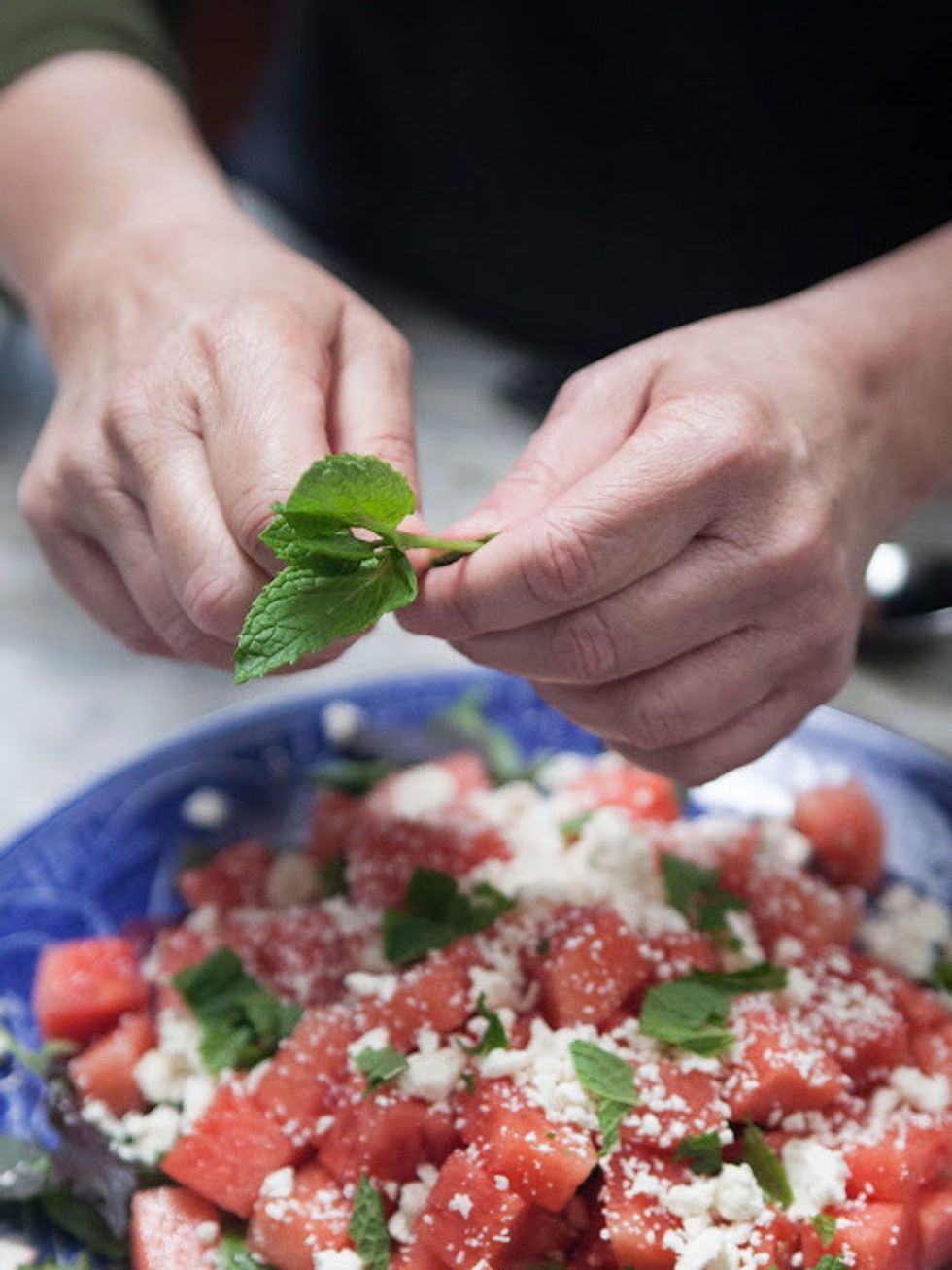 Tear a few mint leaves and sprinkle them over the watermelon and feta cheese.