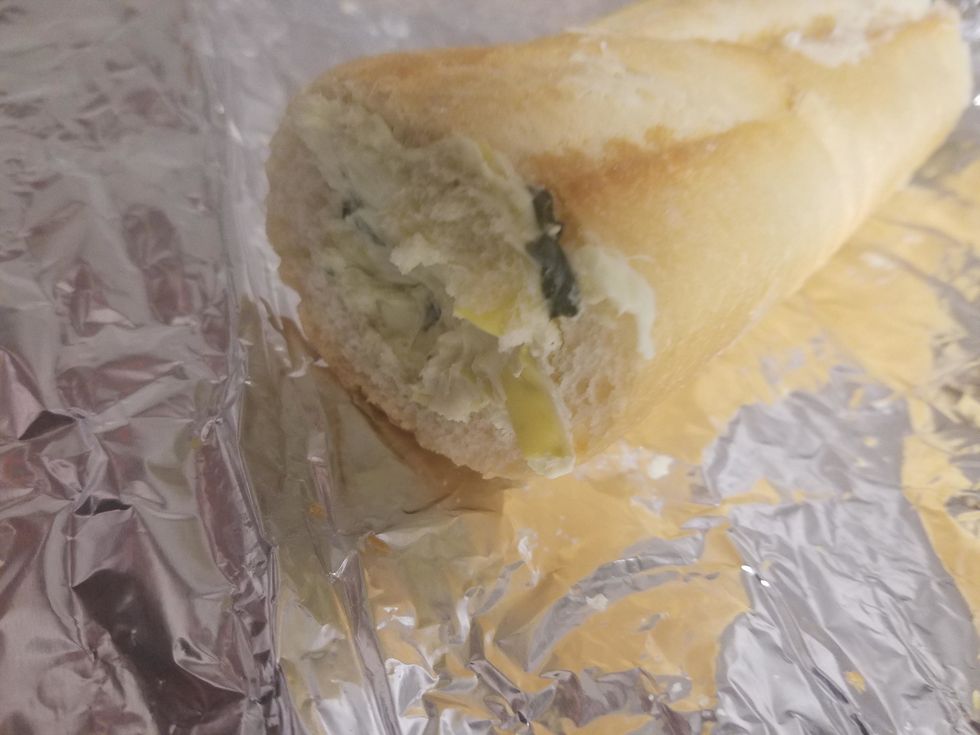 Tear a piece of heavy duty foil that is about 5-6 inches longer than the baguette. Slide the baguette slices off of the cutting board and onto the foil, keeping them together.