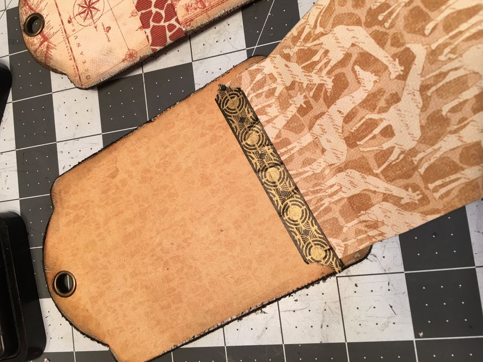 Tear a piece of the Graphic 45 Washi tape and place along the edge of the flap onto the patterned area of the tag.