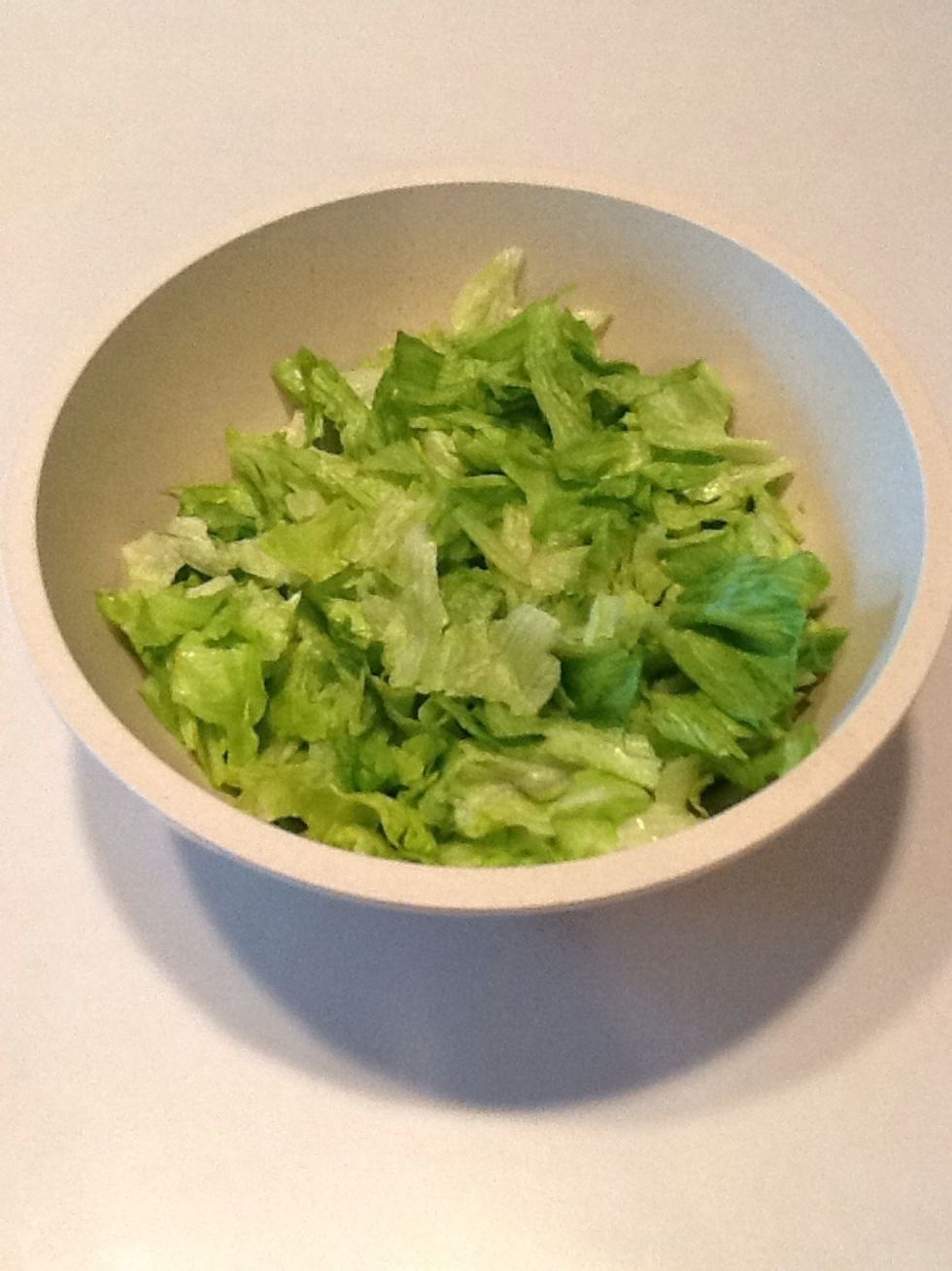 Tear iceberg lettuce and place in bowl.