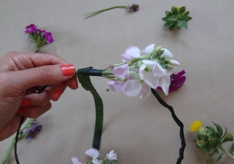 Tear off another long piece of floral tape. Lay your first first flower along the wire headband.