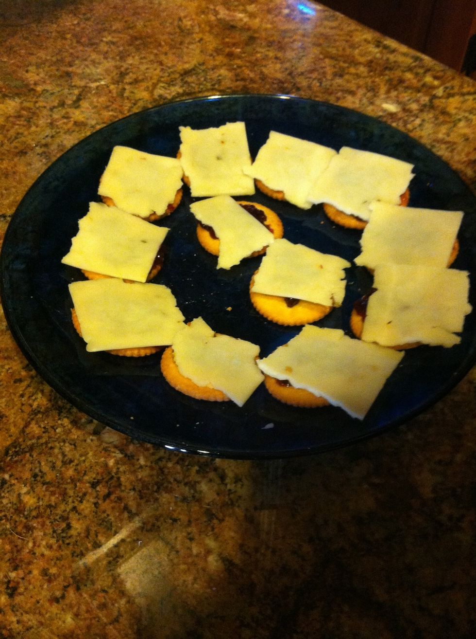 Tear or cut (tearing is faster) the pepper jack cheese squares into four pieces and place on top of the crackers. Enjoy your snack!