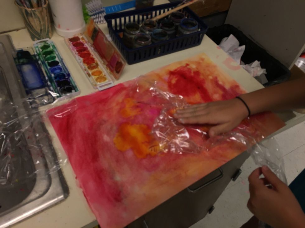 Tear some plastic wrap and lay it directly on the wet paint. Crinkle it. This will add texture as it dries.