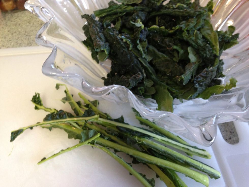 Tear the kale leaves away from the tough rib of each leaf, and into bite-sized pieces. You should end up w salad greens, and a bunch of naked kale spines to discard.