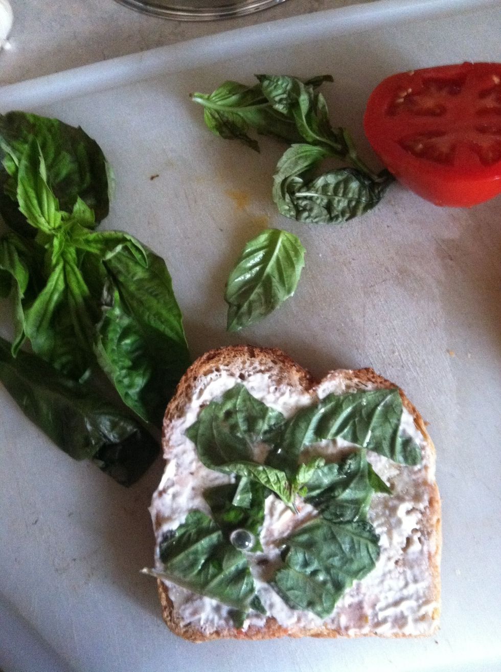 Tear up basil into little pieces and put on the toast
