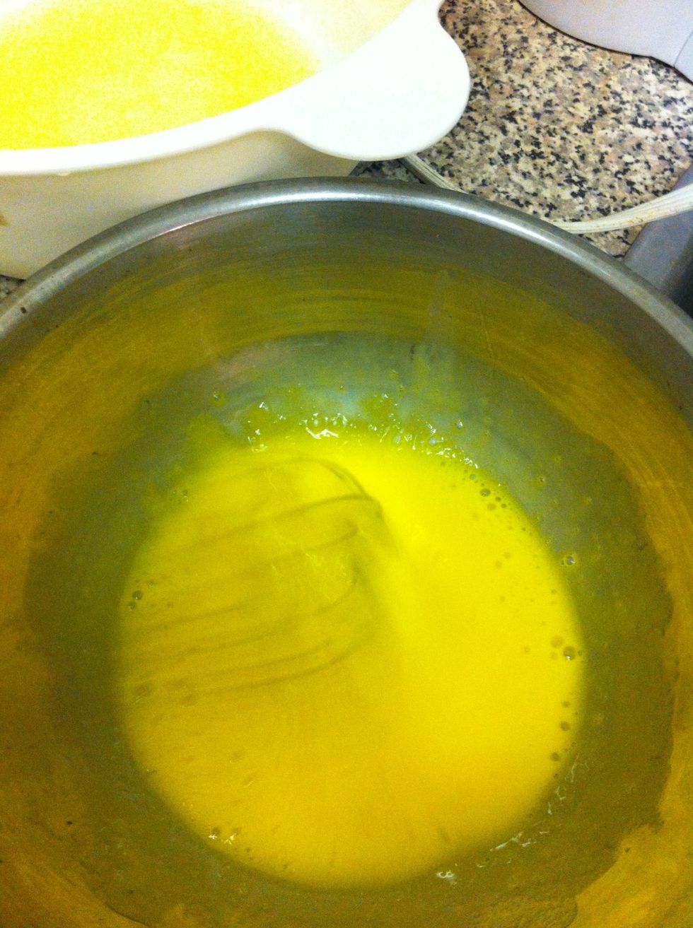 Temper egg yolks by slowly adding in a 1/2 cup of the sugar mixture while whisking briskly. Be sure to keep whisking while pouring in mixture or you'll cook the eggs.
