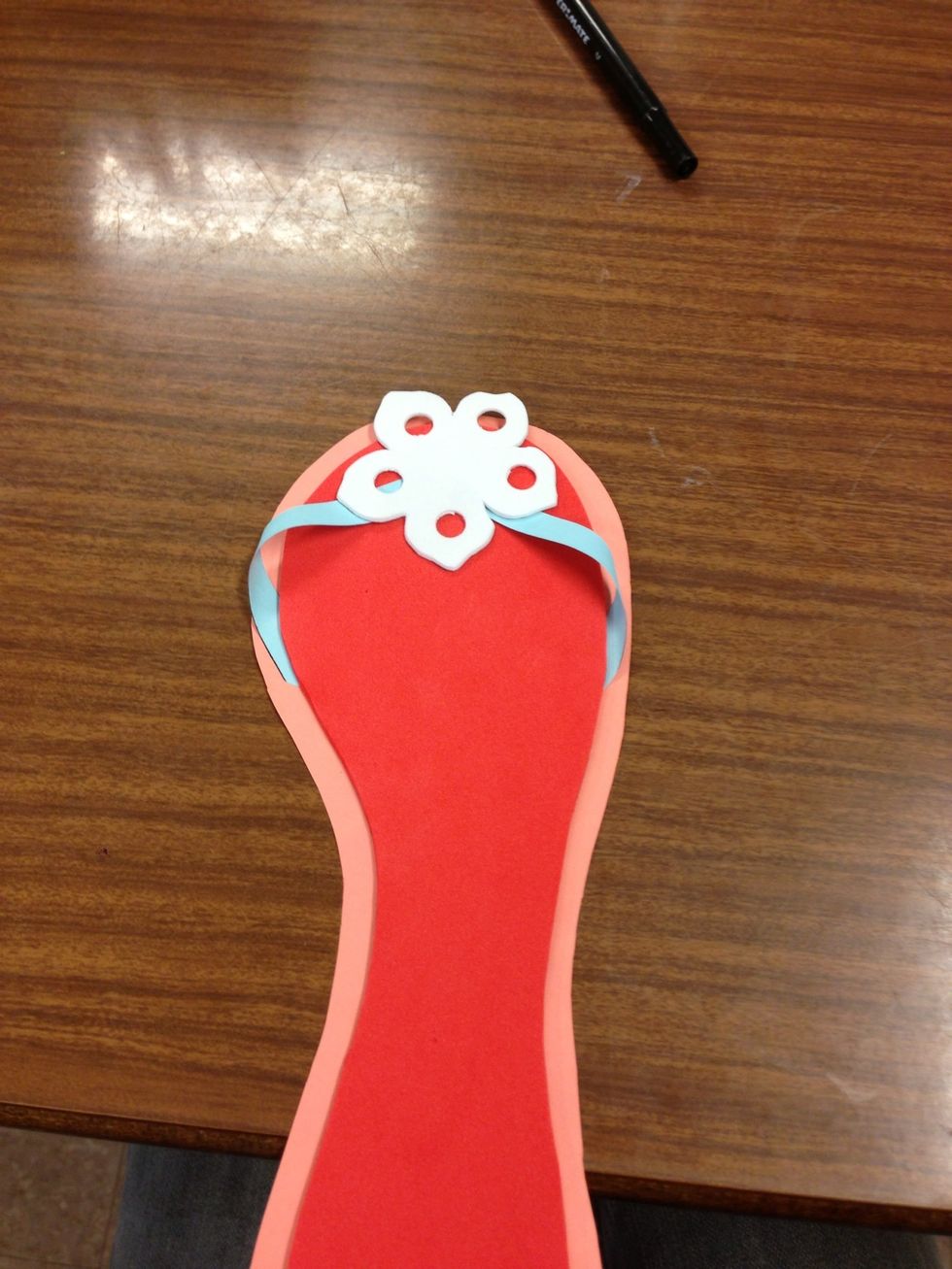 Than start cutting out flower shapes and putting them on the flip flop where the straps join together on the front so it looks like a decoration on the flip flop.