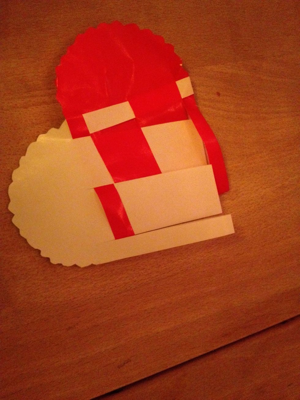 The 1.red strip goes thru the 2.white strip, then the 2.white strip goes thru the 2.red strip and the 3.red strip goes thru the 2.white strip finely the 2.white strip goes thru the 4.red strip.