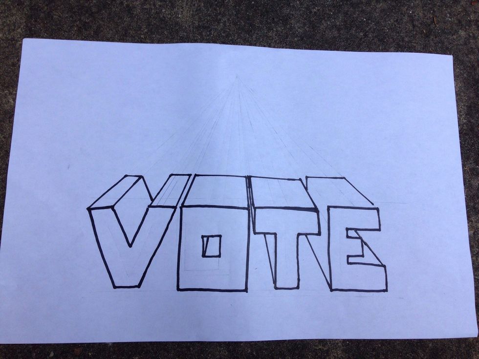 The back edges are now drawn in and the whole word is outlined in marker. All lines leading to the vanishing point should be erased.