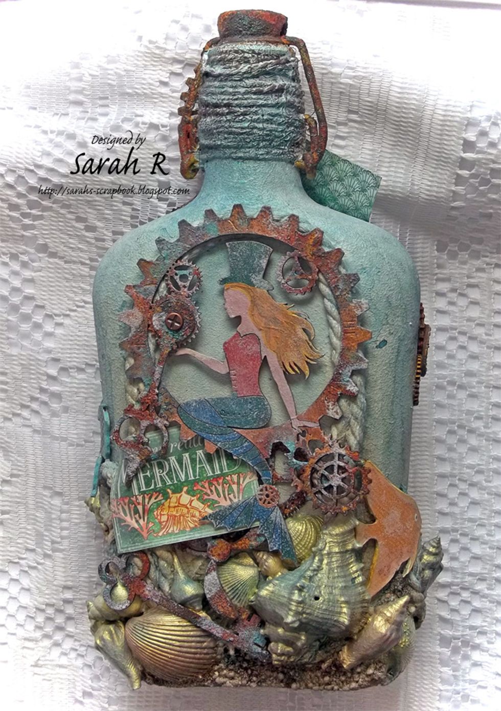 The back of the bottle - featuring the Creative Embellishments Steampunk Mermaid, as well as chipboard gears, key, clock hand & propellers. Another Tropical Fish is 'swimming' towards the front!