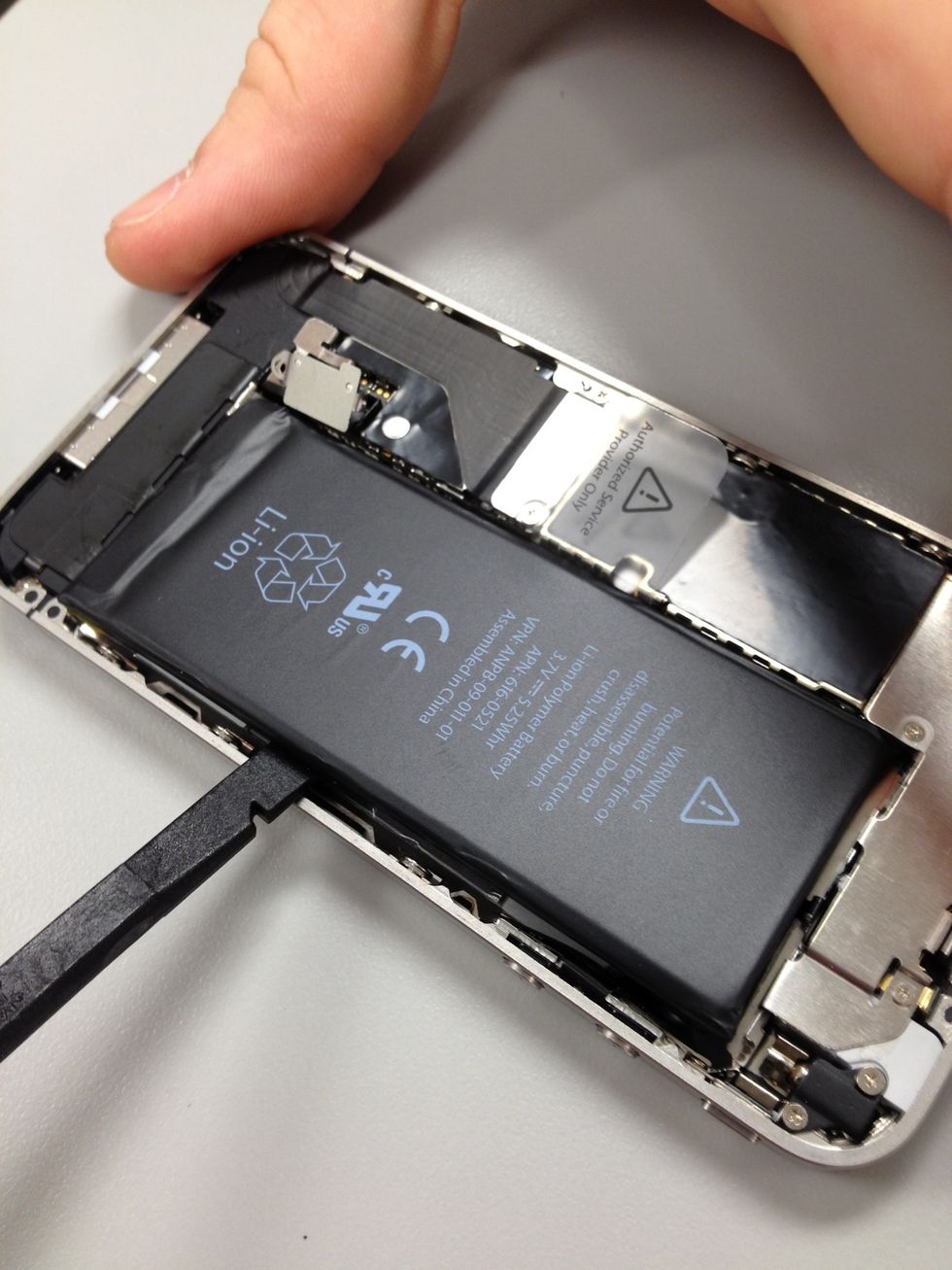 The battery will have adhesive on the backside so you will need to carefully use the spudger to work the area around it and separate it from the mid plate.