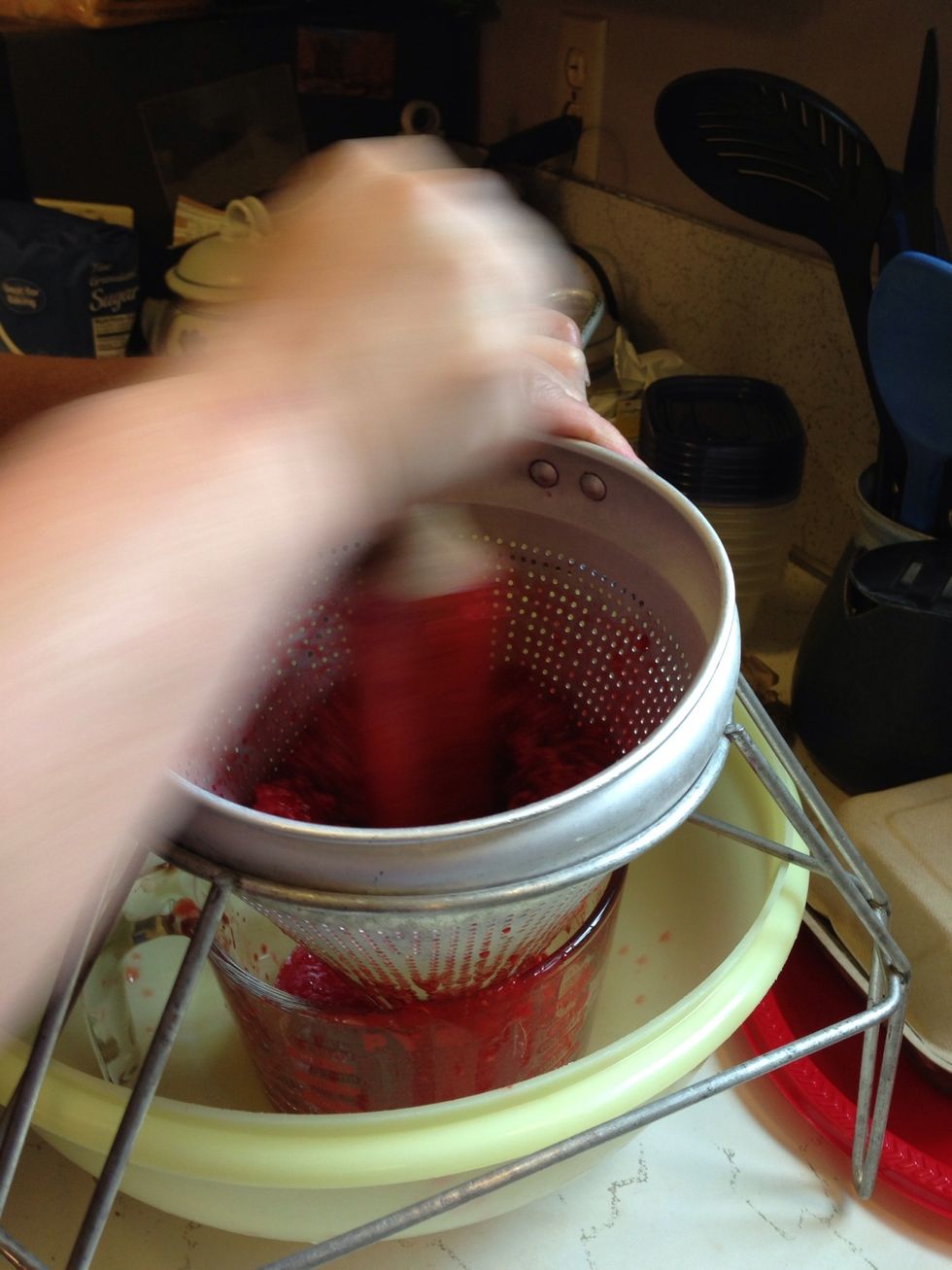 The berry juice will funnel into the cup.