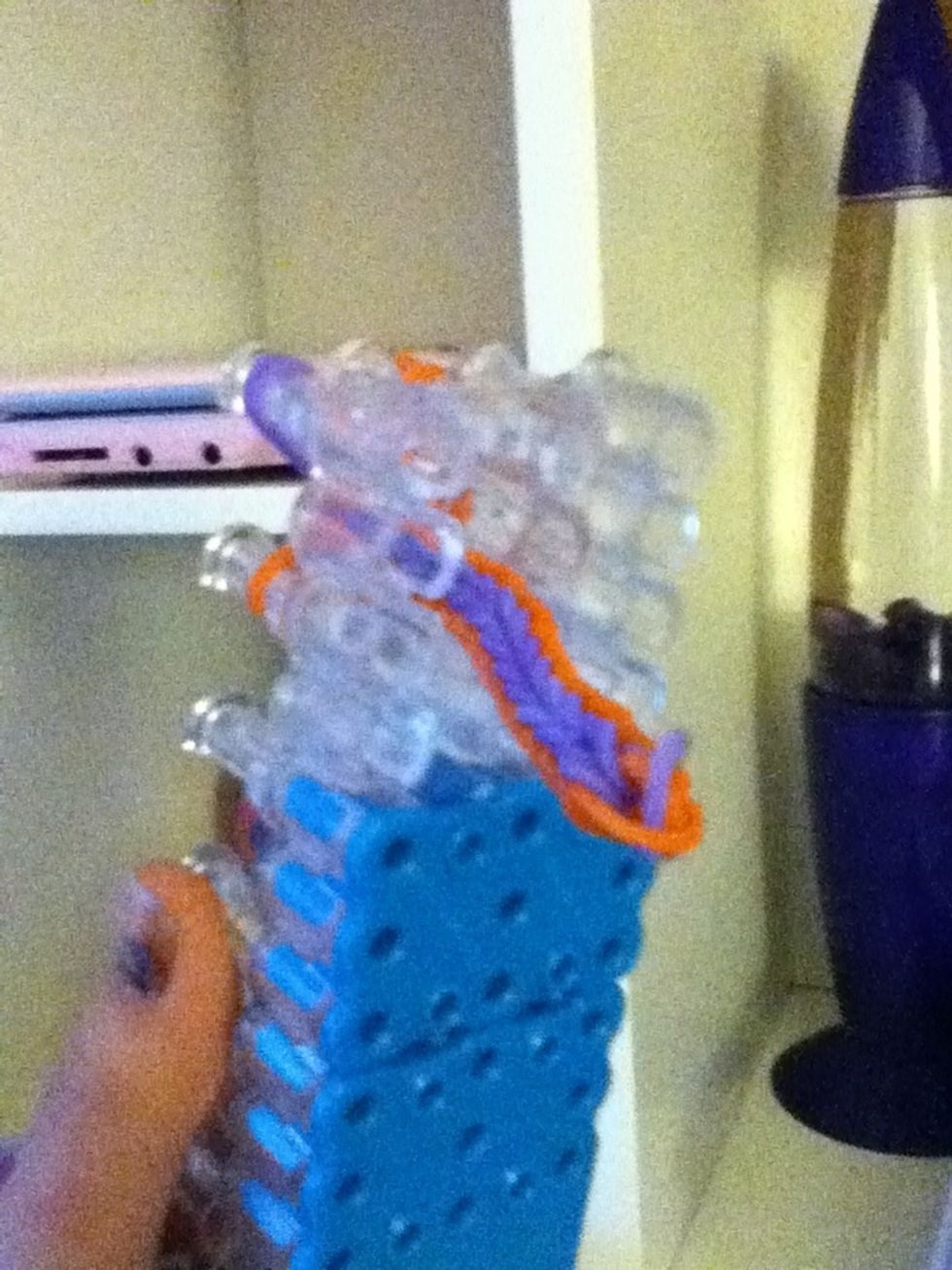 The braclet should come threw the hole at the bottom of the loom