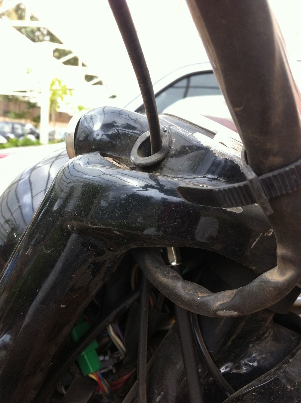 The cable end should come out of the hole in the headlamp casing side