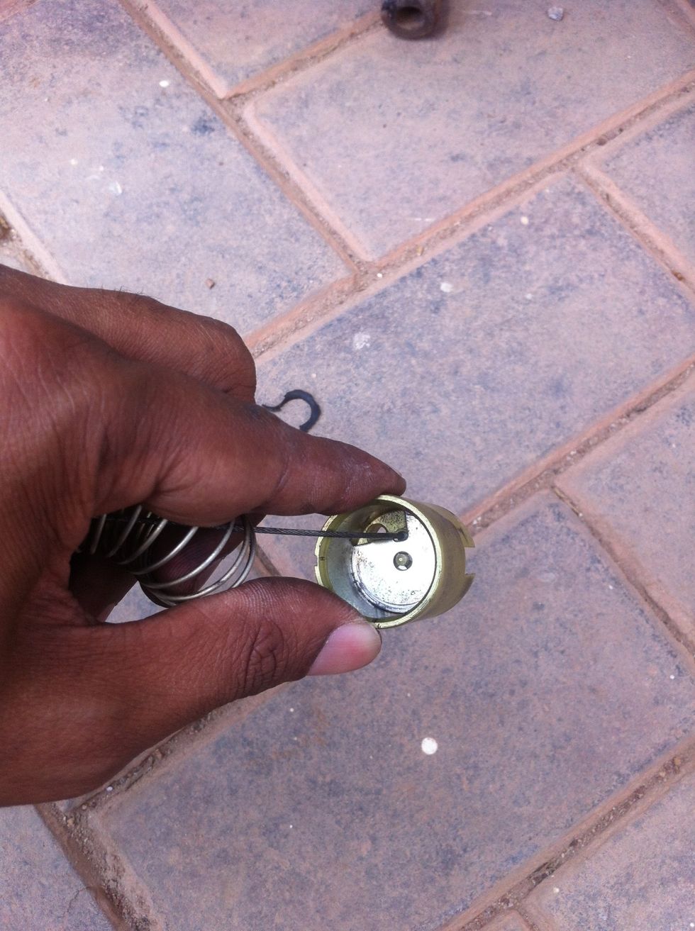 The cable is locked in the piston by a clip.