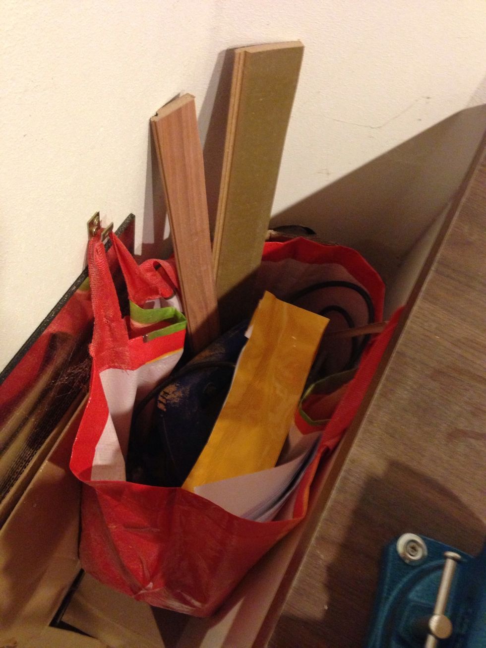 The cheapest trash bin you'll find: A shopping bag hung on two L-brackets (after attaching the brackets bend them so they look like a V)