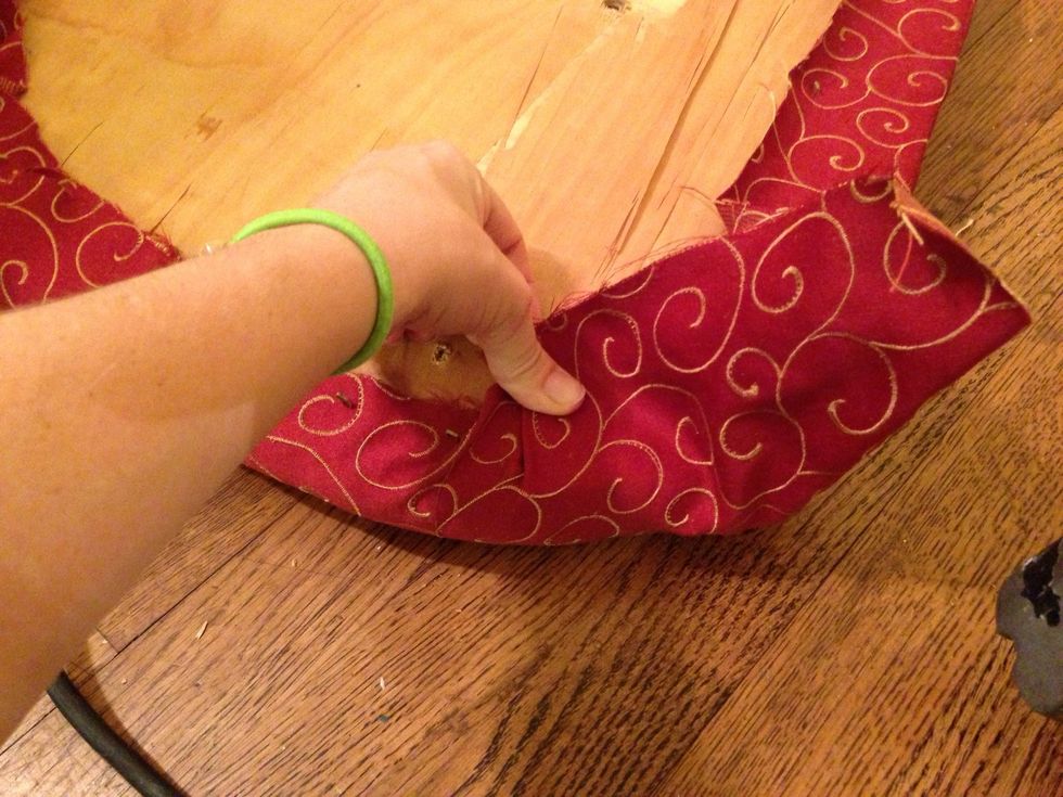 The corners are a bit trickier because you don't want any wrinkles showing. Pull a bit and staple, overlap it and repeat.