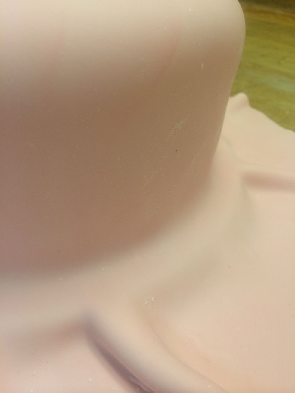 The delicate part is to stretch and pull the fondant over the side of the cake creating no gaps, folds or seams making it one uniform piece.