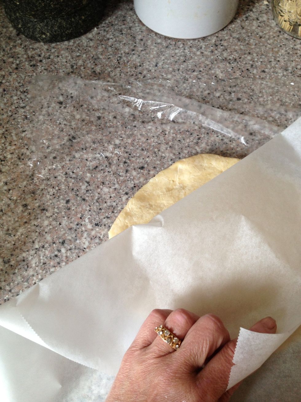 The dough ready for the rolling pin. Place the dough between the plastic wrap and a piece of baking paper. Roll it out a bit bigger than your pie dish.