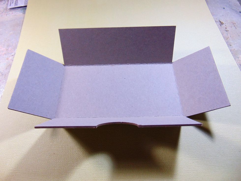 The drawer is the chipboard piece. Bend up the sides where the scores are.........